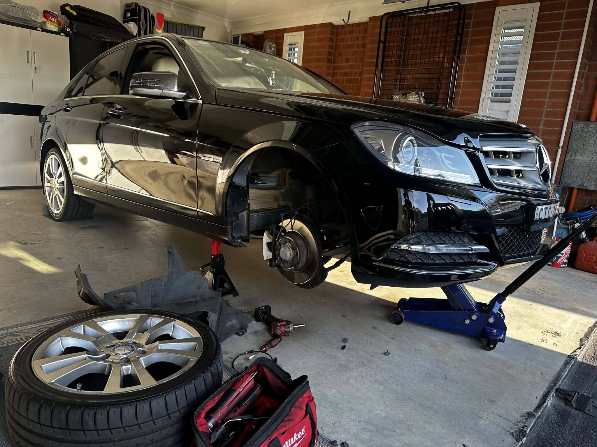Car on a hoist in a workshop—supporting Sparrow's fully equipped mobile mechanic service on the Central Coast NSW